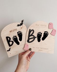 two wooden magnets with baby footprints and bats on them