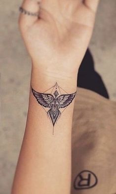 a woman's arm with a small tattoo design on the left side of her wrist