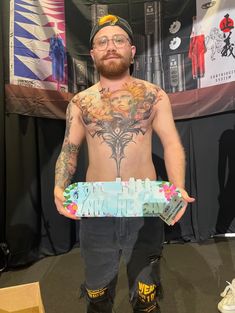 a man with tattoos holding a skateboard in his hands