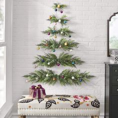 a small christmas tree sitting on top of a wooden bench next to a dresser and mirror