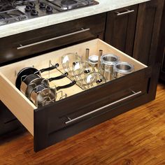 an open drawer in the middle of a kitchen with pots and pans on it