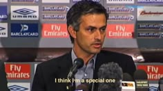 a man in a suit and tie speaking into microphones at a press conference with the words fly emirates on it