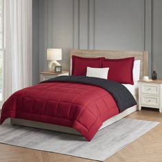 a red and black comforter on a bed in a room