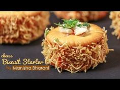 some food that is sitting on top of a black surface with the words, cheesy biscuit starter by manisha bhari