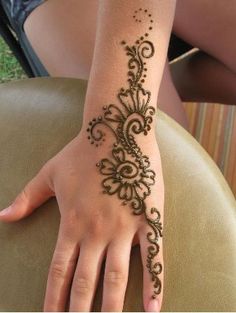 a woman's hand with henna tattoos on it