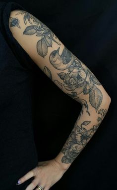 a woman's arm with tattoos on it and her hand in the other direction