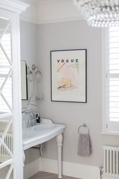 a white sink sitting under a mirror next to a radiator in a bathroom