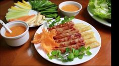 several plates of food on a table with dipping sauces and lettuce leaves