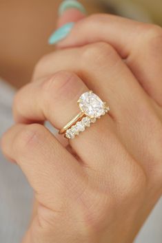 a woman's hand with a gold ring and two diamond rings on her fingers