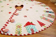 a round quilted table top with christmas decorations on it and a hole in the center