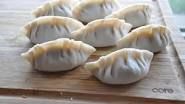 several dumplings are sitting on a cutting board