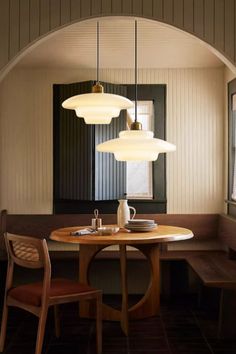 a dining room table with three lights hanging over it