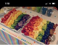 several trays filled with different types of fruits and veggies on a table