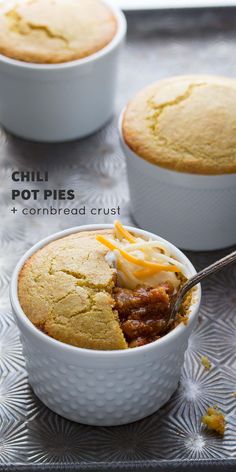 chili pot pies and cornbread crust in white dishes on a silver tray with text overlay