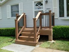 a wooden stair case in front of a white house