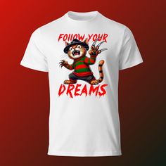 Unleash your inner cat lover with our Follow Your Dreams Cat T-Shirt. This funny and unique novelty tee features a cute and quirky design, perfect for pet owners and cat enthusiasts. Whether you're looking for a playful gift idea or a colorful addition to your wardrobe, this artistic cat tee is sure to delight. Ideal for those who appreciate creative and humorous pet shirts, this striped cat shirt stands out with its retro style and charming cat graphic. Embrace your love for cats with this ador Funny White T-shirt With Cat Design, Funny Short Sleeve T-shirt With Cat Design, Funny Cat Print Crew Neck T-shirt, Dream's Cat, Striped Cat, Pet Shirts, Follow Your Dreams, Cat Graphic, Cat Tee