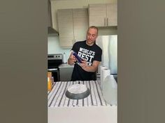 a man standing in front of a cake on top of a kitchen counter next to an oven