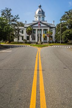 an empty street in front of a large white building