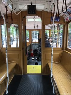 the inside of a bus with wooden benches