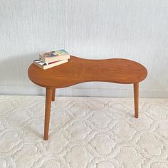 a small wooden bench sitting on top of a white carpeted floor next to a wall