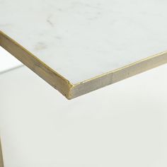 a white marble table with gold trim around the edges and bottom, viewed from above