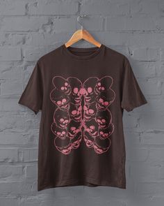 Pink Skulls Shirt Printed on a super soft, cotton tee Dispatched in 5 working days or sooner Unisex Free UK delivery Material: 100% ringspun cotton. Chest (to fit): S  34/36   M  38   L  40/42   XL  44/46   XXL  48/50 ECO-FRIENDLY Each garment is made to order, reducing extra material and energy that would be otherwise wasted We use DTG printing process which is easier on the environment than screen-printing Our ink is bright and also eco-friendly. Do not tumble dry. Wash at 30 degrees c, inside Pink Punk Top For Halloween, Pink Grunge Halloween T-shirt, Pink Grunge T-shirt For Halloween, Black Cotton Pastel Goth Top, Black Cotton Tops In Pastel Goth Style, Gothic Screen Print Tops For Alternative Fashion, Pastel Goth Short Sleeve T-shirt For Streetwear, Pastel Goth Graphic Print Tops For Streetwear, Gothic Tops With Screen Print For Alternative Fashion