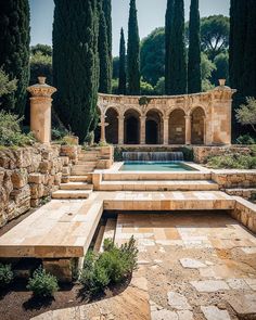 an outdoor pool surrounded by stone steps and trees