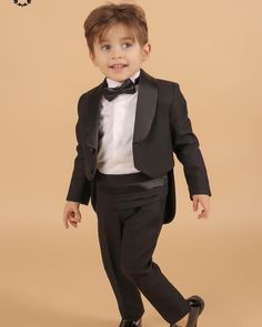 a young boy dressed in a tuxedo and bow tie