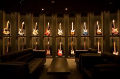 a room with guitars on the wall and couches