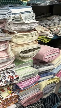 many folded shirts are stacked on top of each other