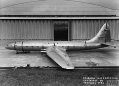 an airplane parked in front of a hangar