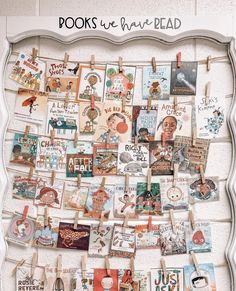 a bulletin board with pictures and clothes pins hanging on it's sides in front of a white wall