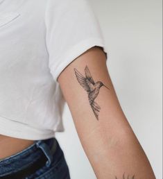 a small bird tattoo on the left arm