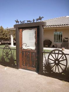 an old fashioned wooden door in front of a house with a horse drawn wagon on it