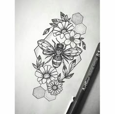 a drawing of flowers and a bee on paper with a marker pen next to it