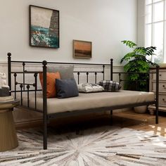 a bedroom with a metal bed frame and white rug on the floor next to a window