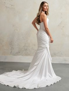 a woman in a white wedding dress posing for the camera with her hands on her hips