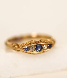 AVictorian 18k Gold Sapphire & Diamond Dress Ring A European Import dating to the early 20th century Victorian Era.  Created in 18k yellow gold scroll with 3 Sapphires and 2 Diamonds.  A treasure. Ladies Size 9 18k Yellow Gold 3 Sapphires 2 Diamonds Arrives in gift box Exclusively from Erin Pelicano Curated Vintage Collection. Each piece is intentionally chosen, pre owned, and ready to be loved and cherished again. sold as shown. Shop the Curated Vintage Collection Elegant Gold Ring With Historical Design, Victorian Gold Rings For Vintage Events, Antique Yellow Gold Rings For Vintage Events, Heirloom Yellow Gold Rings For Vintage Events, Victorian Rings Vintage, Victorian Gold Ring, Grandmother Jewelry, Diamond Dress Ring, Rose Gold Plated Ring