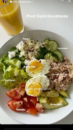 a white plate topped with salad next to a glass of orange juice