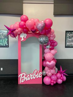 a pink frame with balloons and stars on the top is for a barbie birthday party