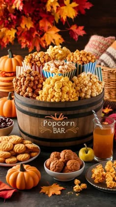 a barrel filled with lots of different types of food next to pumpkins and other foods