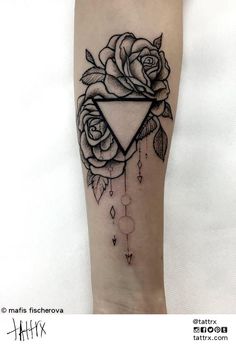 a black and white rose tattoo on the arm with an arrow in the center, surrounded by leaves