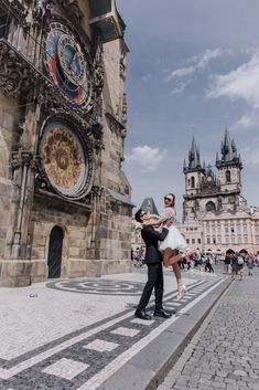 a man holding a woman in front of a building