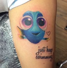 a tattoo with an image of a blue fish on it's left arm and the words, just keep swimming