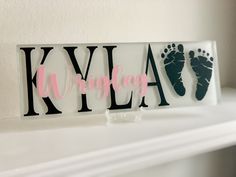 a sign that says klya and baby feet on it