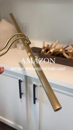 a person is holding a metal object in front of a counter with logs on it