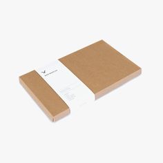 a brown notebook with a white paper on top