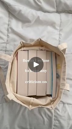 an open book sitting on top of a bed next to a white bag with the words boy, because it's not any critteism on