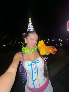 a woman wearing a birthday hat and holding a stuffed animal in her hand with the word happy on it