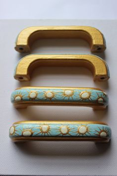 three wooden handles with flowers painted on them